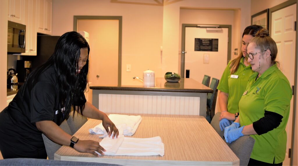 Aqua Green team members folding towels while a supervisor looks on